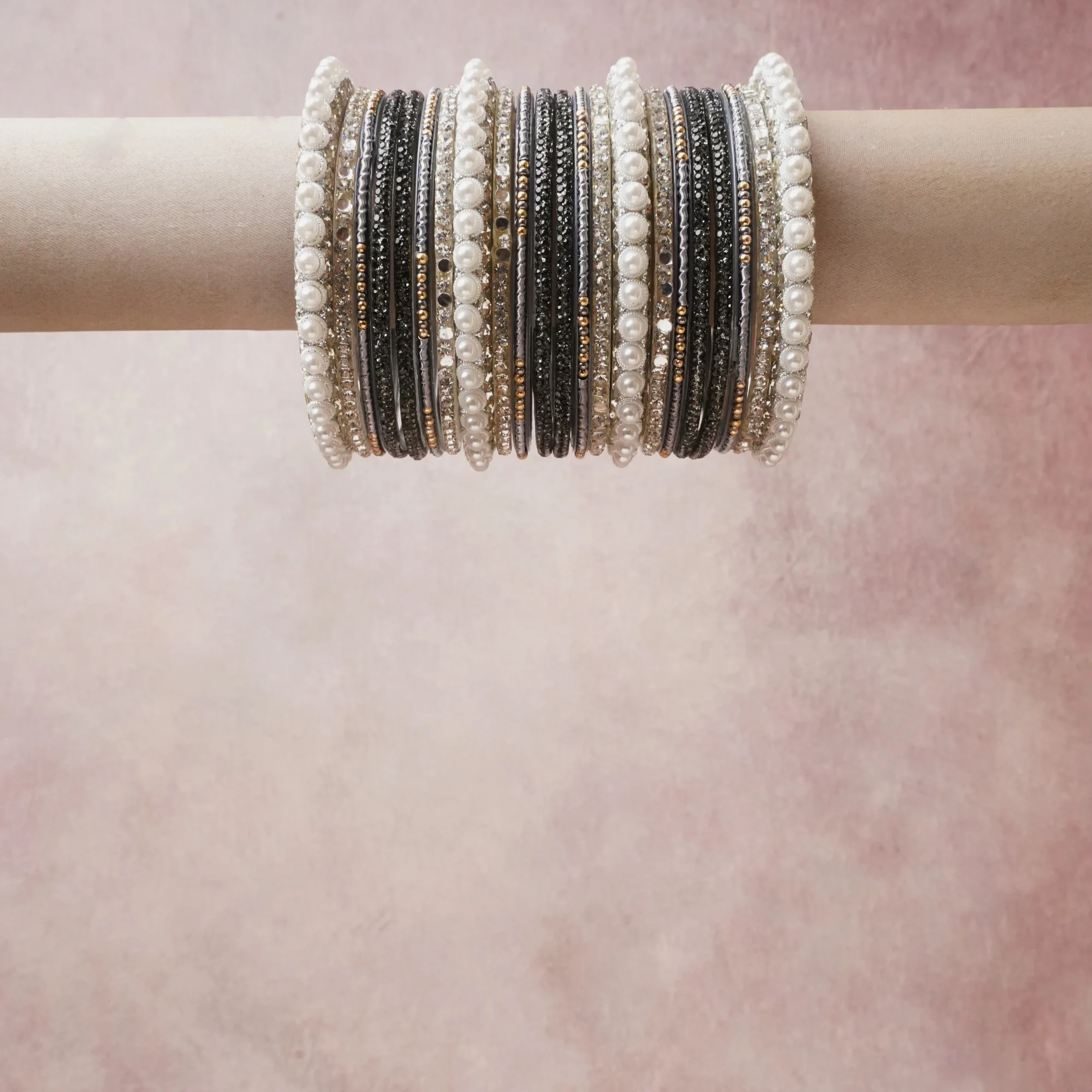 A grounding black forms the heart of the set, while touches of pearl white, silver, rose gold add charm.

A thoughtful composition of beaded metal and pearl stretch bracelets, designed to feel complete without being heavy.
Each element layers seamlessly, creating a look that is refined, wearable and quietly striking.