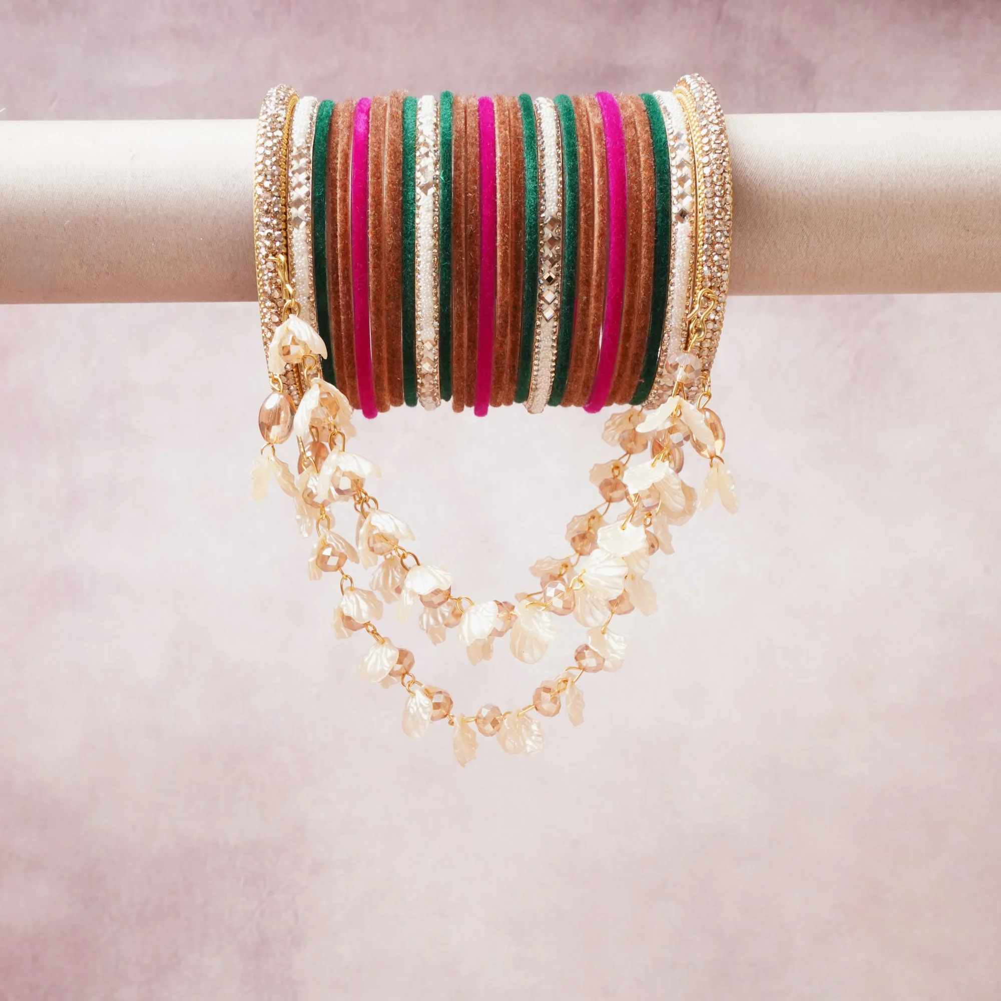 A commanding Gold anchors this beautiful set, enriched with accents of pink, Emerald Green, Ivory that add depth and dimension.

Featuring a striking composition of glass bangle, gold-toned metal, faux pearl, this set carries intricate craftsmanship and strong presence. Grand in form, it is created for moments that deserve to be marked.