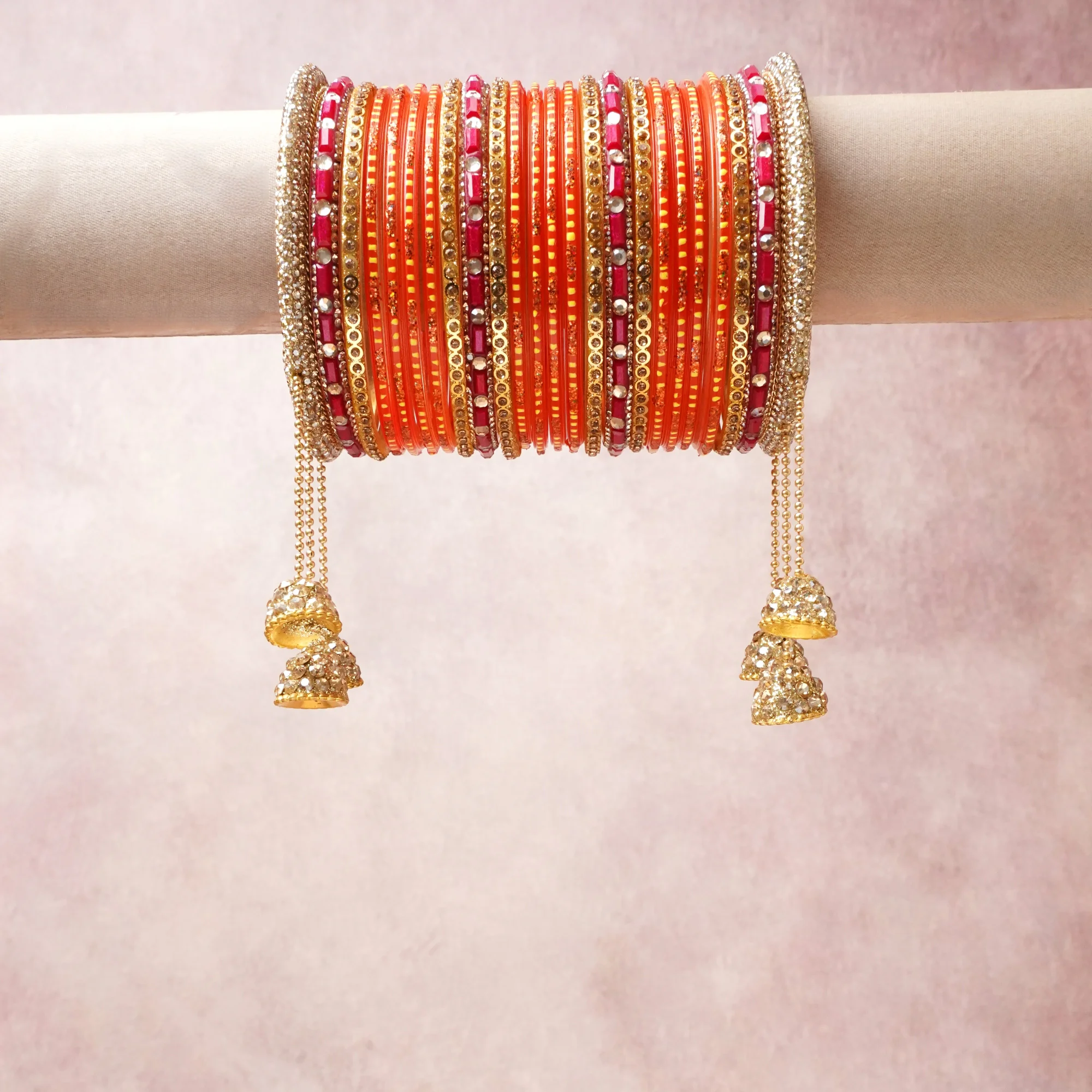 A commanding orange anchors this beautiful set, enriched with accents of gold, pink, white that add depth and dimension.

Featuring a striking composition of glass bangles, gold-tone metal, rhinestone embellishments, this set carries intricate craftsmanship and strong presence. Grand in form, it is created for moments that deserve to be marked.