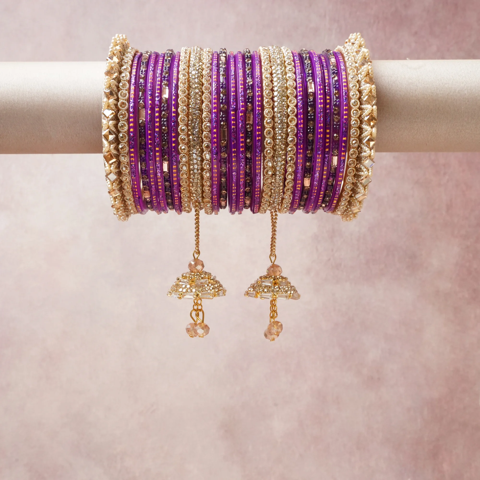 A commanding Royal Purple anchors this beautiful set, enriched with accents of Gold, Champagne that add depth and dimension.

Featuring a striking composition of Glass Bangles, Rhinestones, Gold-Tone Metal, this set carries intricate craftsmanship and strong presence. Grand in form, it is created for moments that deserve to be marked.