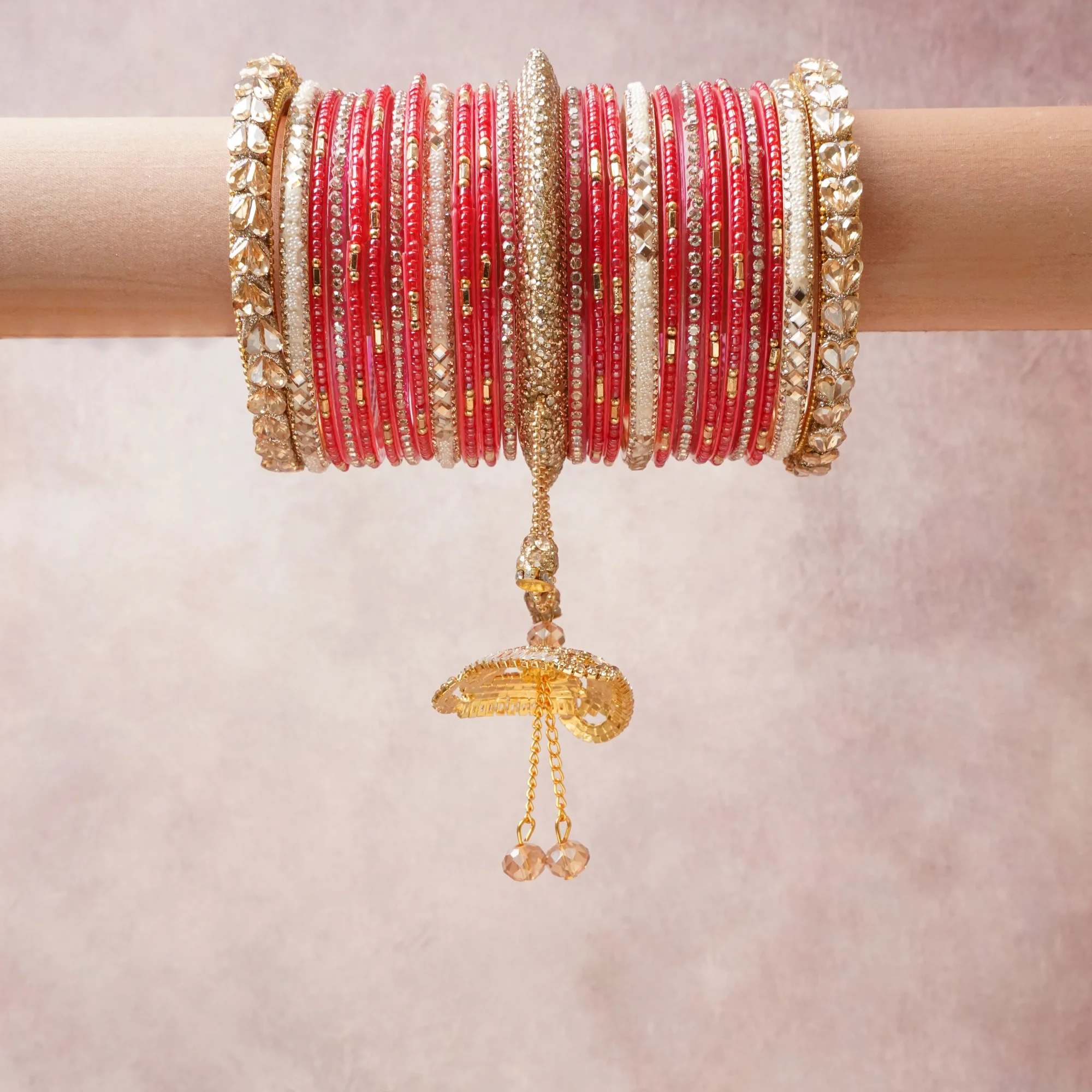 A commanding Blush Pink anchors this beautiful set, enriched with accents of Gold, White that add depth and dimension.

Featuring a striking composition of glass bangles, rhinestone, gold-tone metal, this set carries intricate craftsmanship and strong presence. Grand in form, it is created for moments that deserve to be marked.