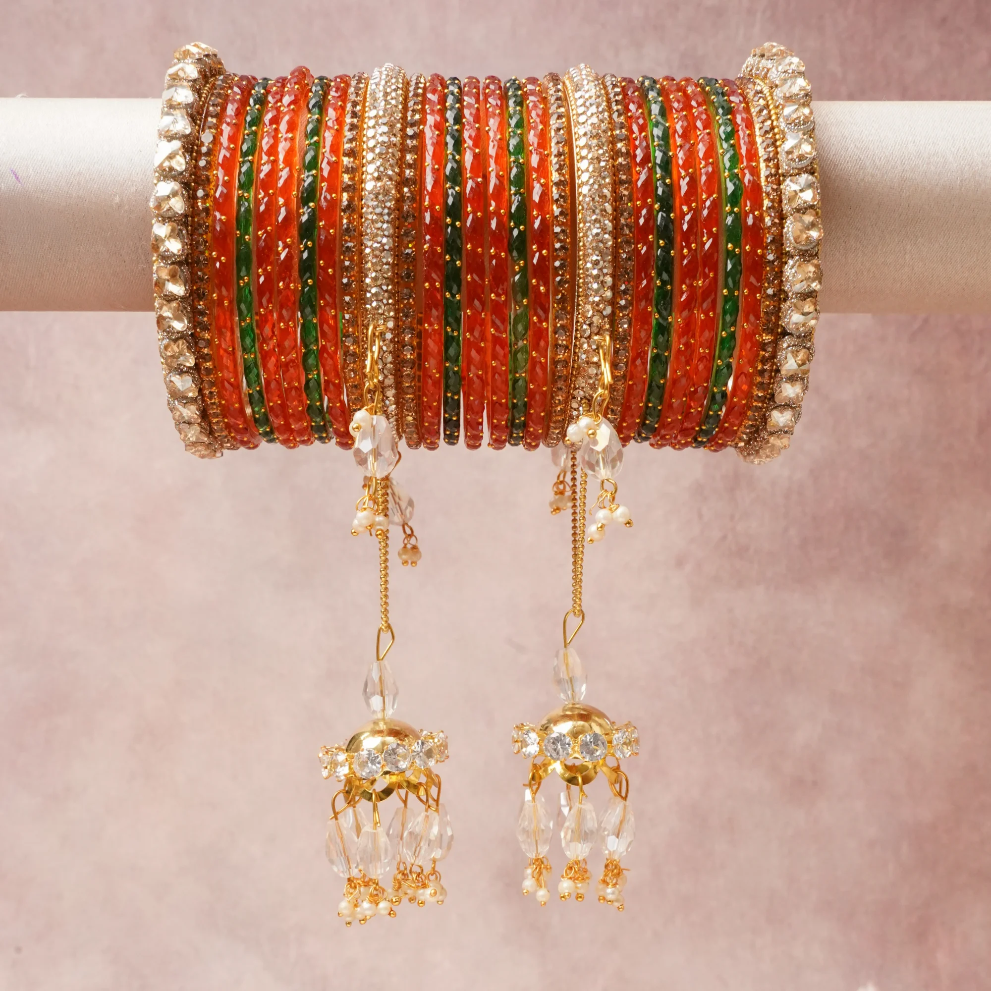 A commanding gold anchors this beautiful set, enriched with accents of orange, green, clear crystal that add depth and dimension.

Featuring a striking composition of glass bangles, gold-toned metal, rhinestones, this set carries intricate craftsmanship and strong presence. Grand in form, it is created for moments that deserve to be marked.