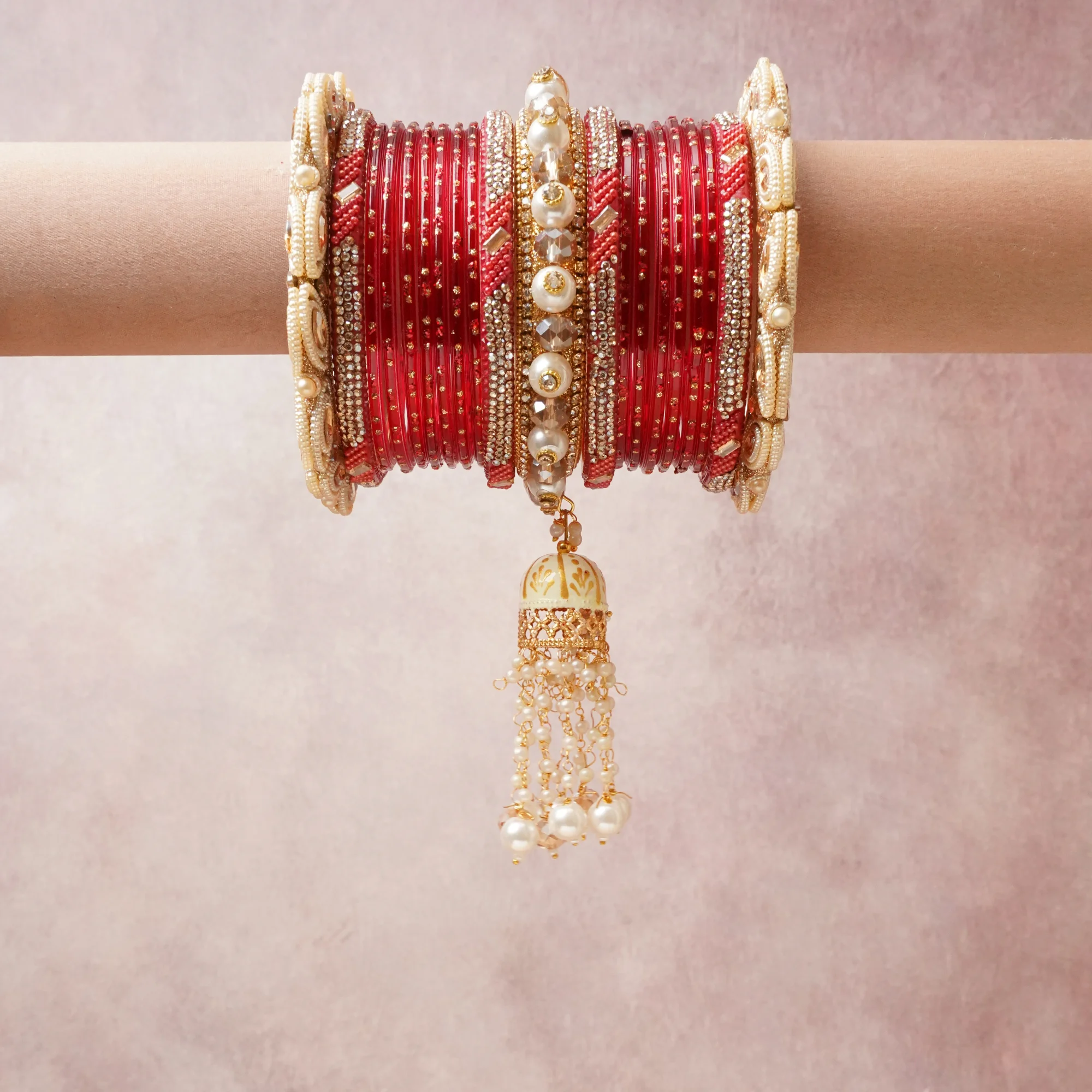A commanding red anchors this beautiful set, enriched with accents of gold, ivory, pearl white that add depth and dimension.

Featuring a striking composition of glass bangles, faux pearls, rhinestones, this set carries intricate craftsmanship and strong presence. Grand in form, it is created for moments that deserve to be marked.